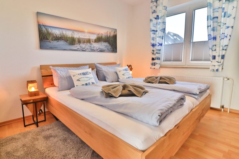 Doppelbett 180 x 200 im Schlafzimmer der Ferienwohnung Strandleben mit großem Bild über dem Bett und tollen Nachttischlampen